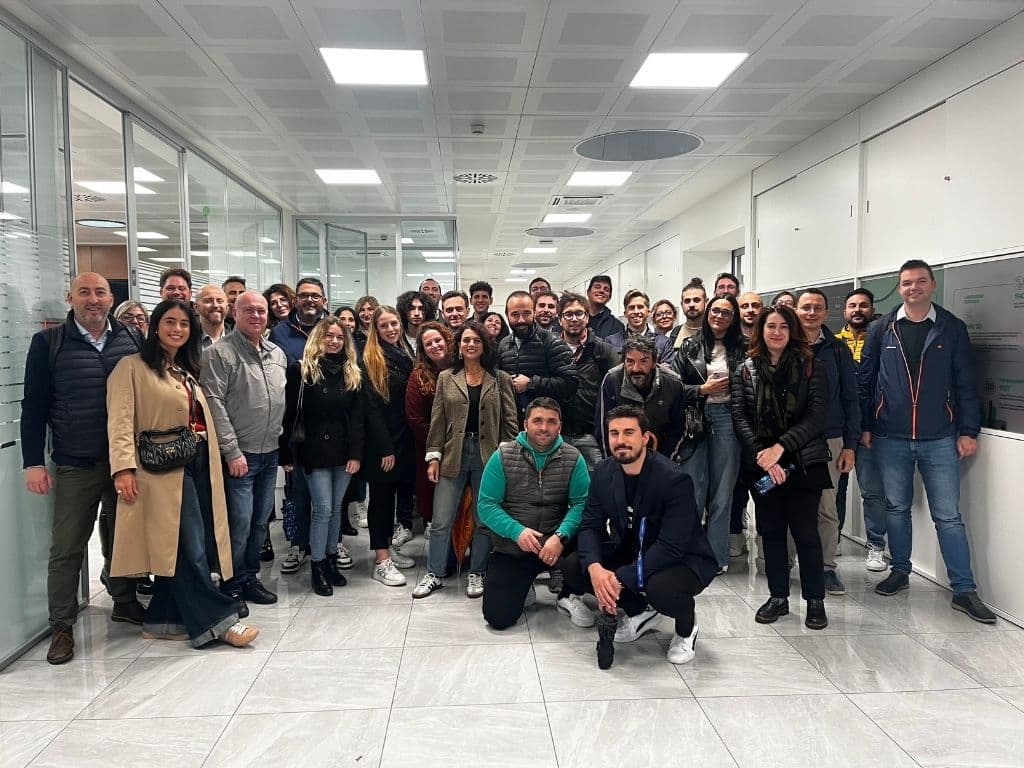 Group of people gathered in a modern office hallway for a team event or meeting