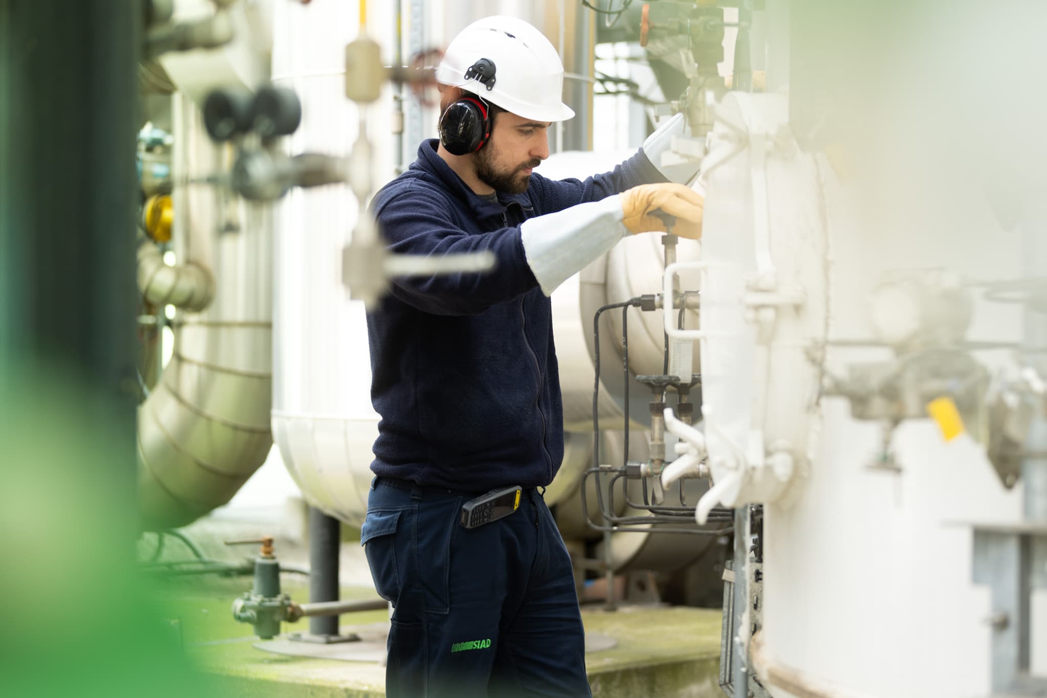 SIAD employee performing maintenance work on an industrial plant system